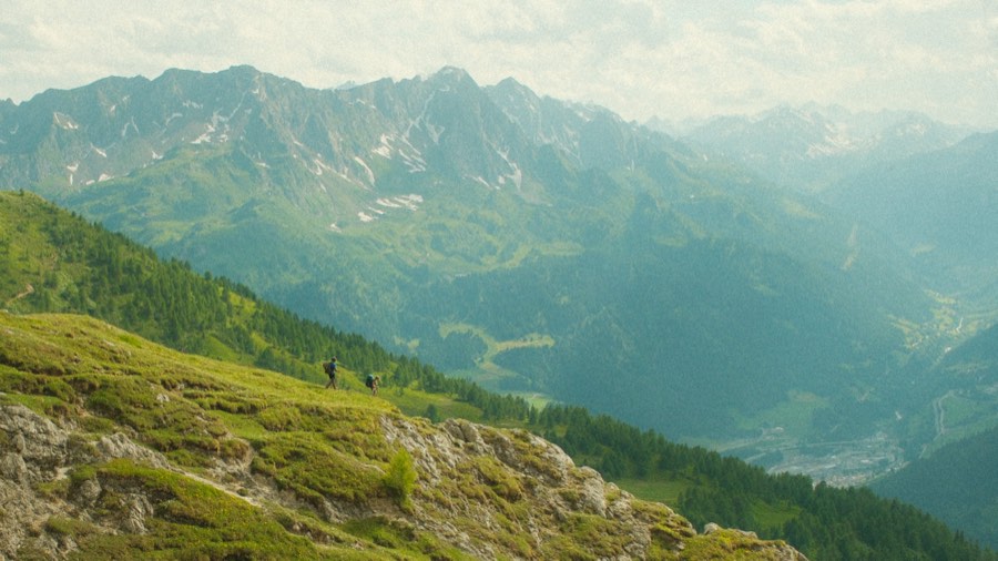 Hikers on an alpine ridge above the valley